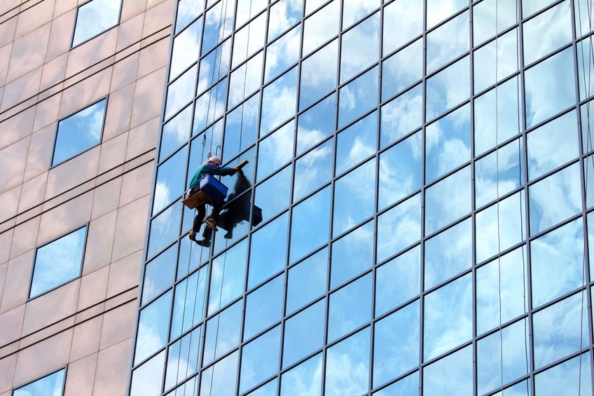 9937231 - window cleaner hanging on rope at work on skyscraper